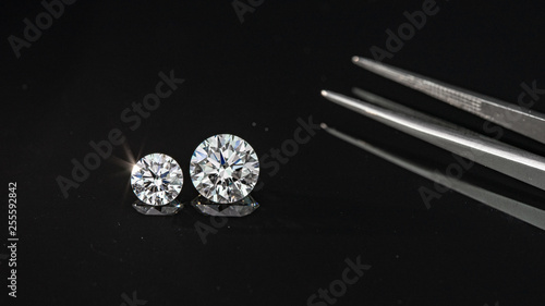 Compared 1.00 and 2.50 carat size diamonds on black background
