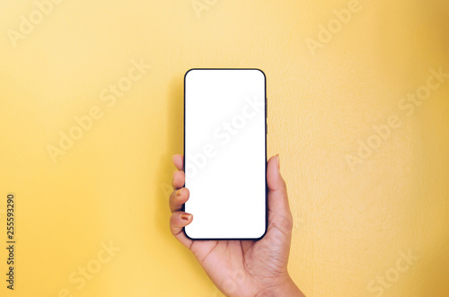 Human hand holding smartphone with white screen background.