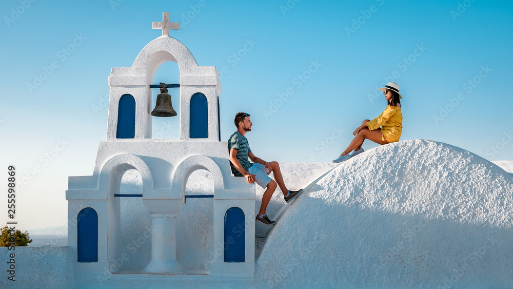 young couple on vacation in Santorini Greece, luxury holliday vacation Oia Santorini Greece - obrazy, fototapety, plakaty 