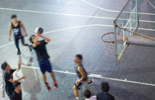 High angle view of young Asian people playing basketball outdoor at night