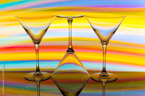 Three cocktail / martini glasses in a row with colorful streaks of light painting behind