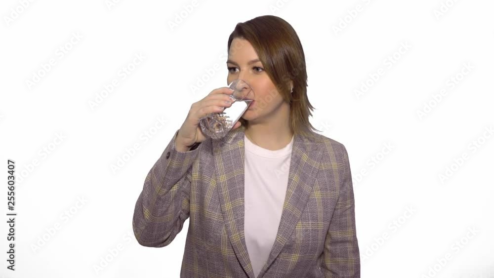 Young cheerful caucasian woman drinking clean water and showing thumbs up over white background chroma key Young cheerful caucasian woman drinking clean water and showing thumbs up over white background chroma key