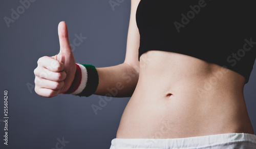 Beautiful and strong womans abs show hand OK