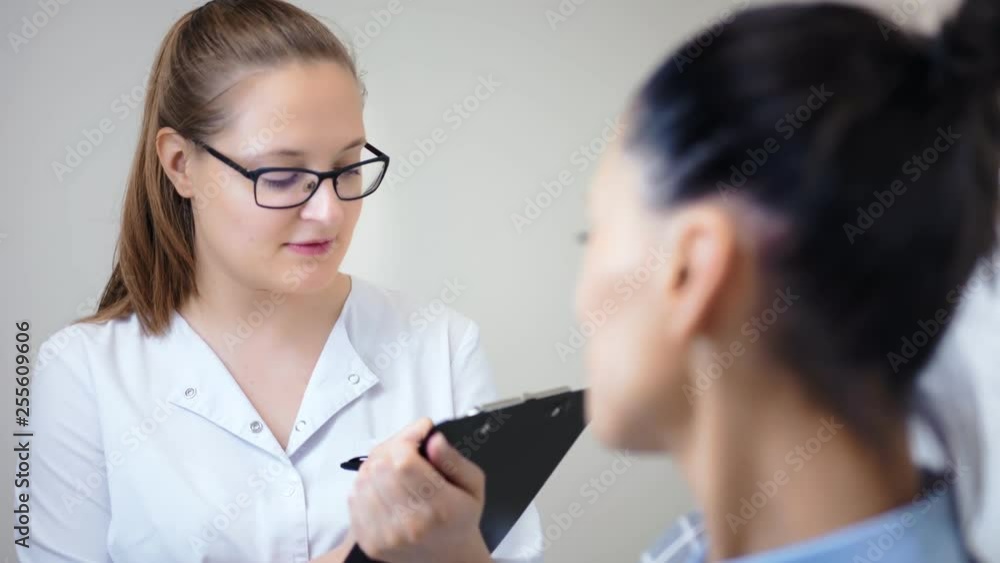 Caring smiling woman in medical uniform consulting female patient before medicine procedure
