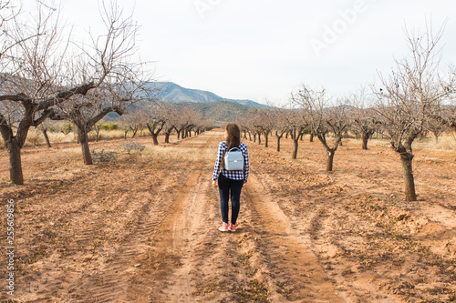 Holiday, travel and tourism concept - Young woman with stylish backpack on summer nature © satura_