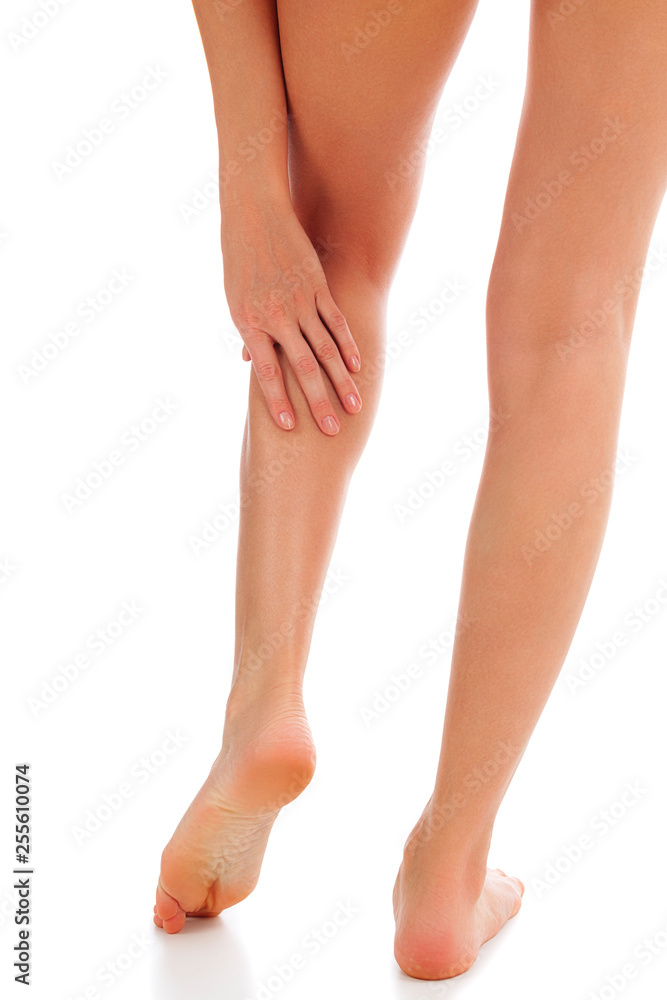 Woman touches her painful shin, isolated on white background Woman touches her painful shin, isolated on white background