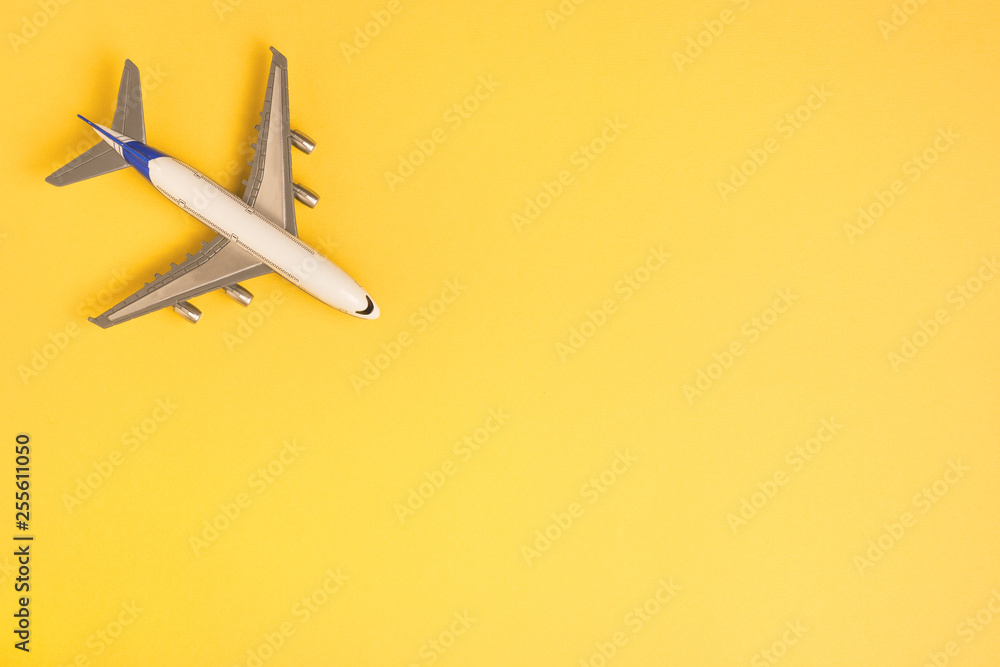 Flat lay airplane on yellow background. Concept of travel.