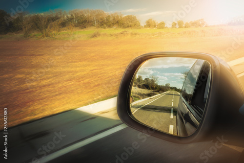 Road view in the car rear-view mirror