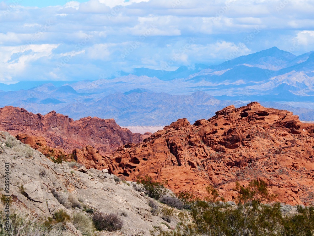 red rock formations and mountains with clouds