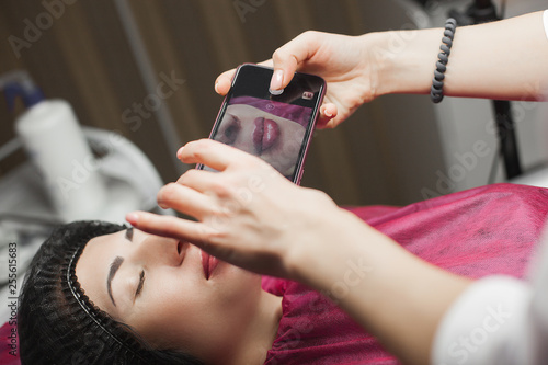 Cosmetologist making an ingection to her client. Woman beauty procedure, lip augmentation procedure. Antiageing treatment. photo