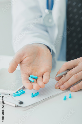 Doctor holding pills in his hand