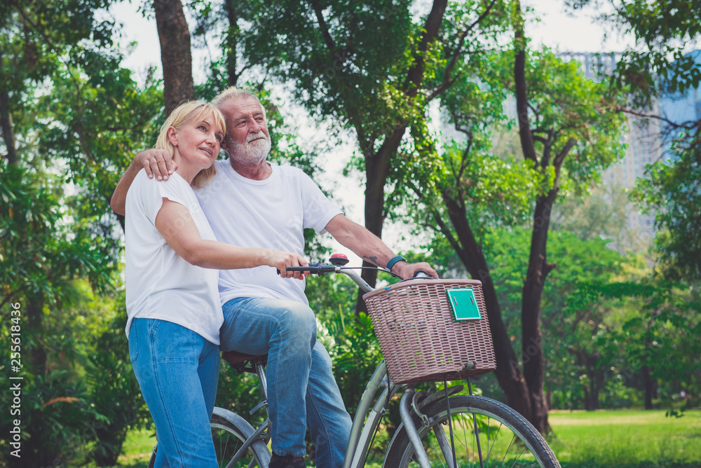 Senior Couple Riding Bikes In Park Senior Couple Riding Bikes In Park