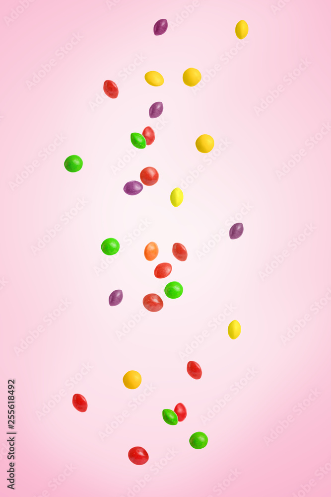 Falling colored candy, sweets. On a pink background Falling colored candy, sweets. On a pink background