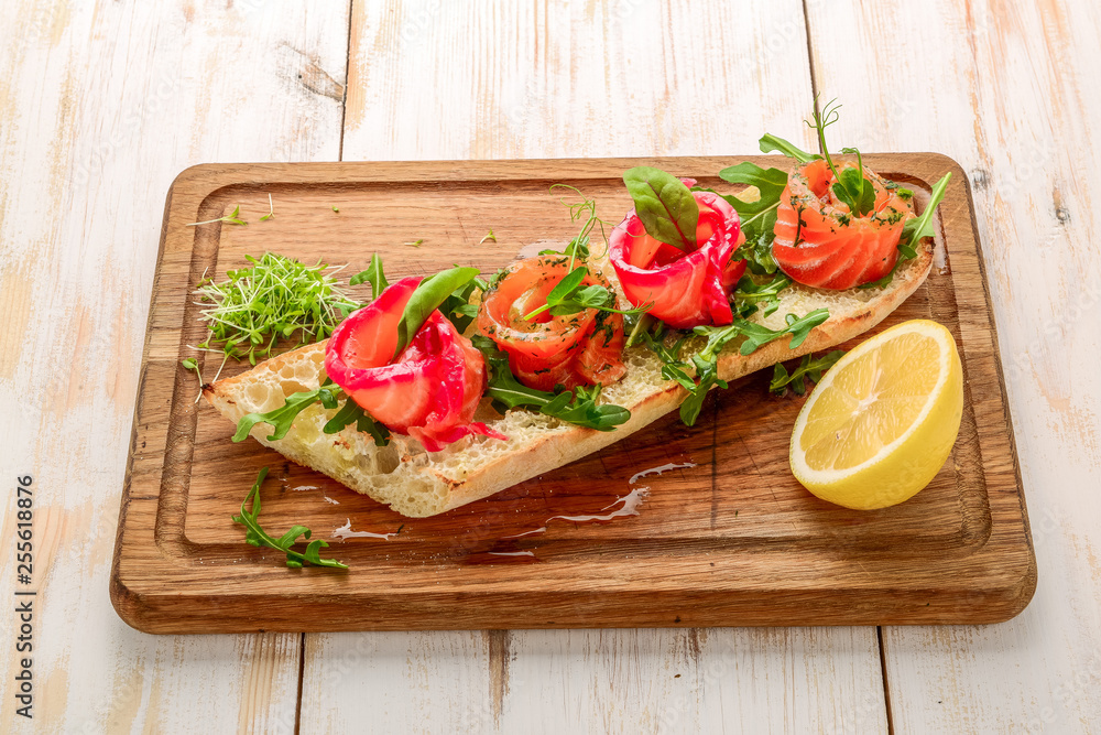 Sandwich with toasted bread and salmon on a wooden table Sandwich with toasted bread and salmon on a wooden table