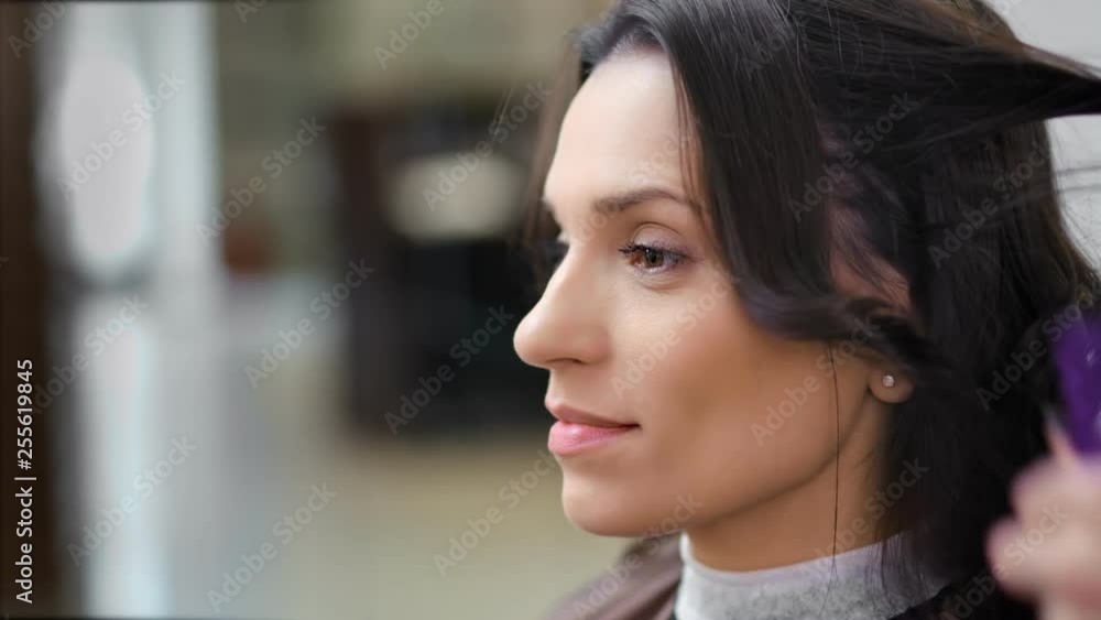 Close-up face of positive pretty woman enjoying curling hair styling at luxury beauty salon Close-up face of positive pretty woman enjoying curling hair styling at luxury beauty salon