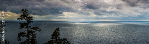 panoramic aerial view on the huge lake Vättern in Sweden; sun rays struggle through the clouds making light sun spots on ripple water surface