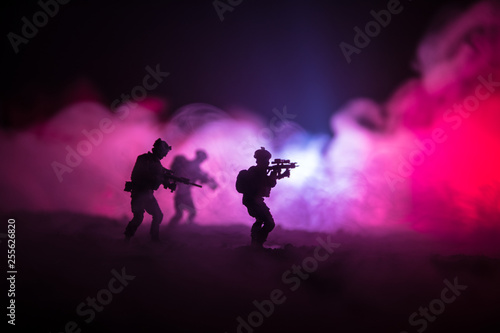 Military soldier silhouette with gun. War Concept. Military silhouettes fighting scene on war fog sky background, World War Soldier Silhouette Below Cloudy Skyline At night.