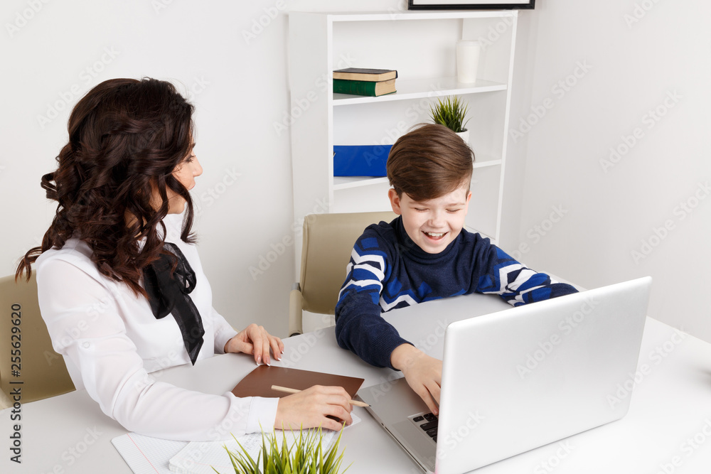 Doing homework on the laptop. Child doing homework and his teacher helps Doing homework on the laptop. Child doing homework and his teacher helps