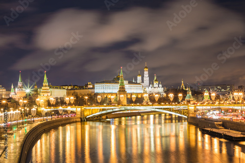 Illuminated Moscow Kremlin and Bolshoy Kamenny Bridge in the rays of setting sun. View from the Patriarshy pedestrian Bridge in Russia. Evening urban landscape in the blue hour © Майджи Владимир