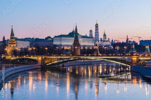 Illuminated Moscow Kremlin and Bolshoy Kamenny Bridge in the rays of rising sun. View from the Patriarshy pedestrian Bridge in Russia. Morning urban landscape in the blue hour © Майджи Владимир