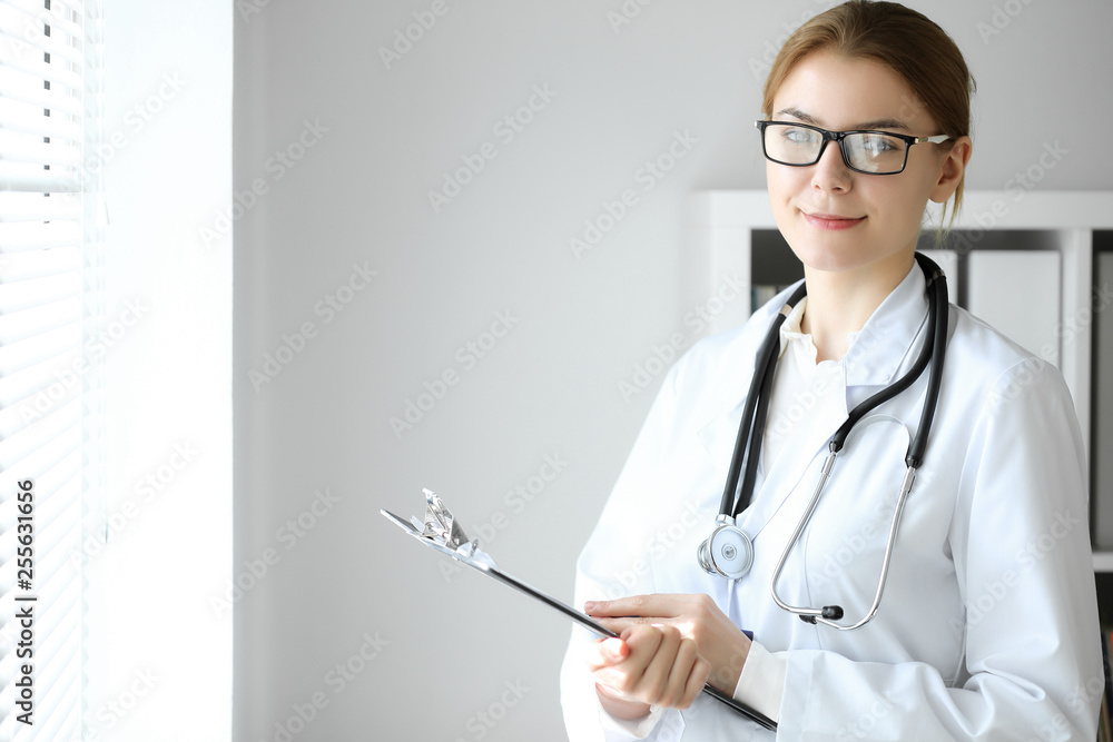 Doctor woman at work. Portrait of female physician using clipboard at hospital office. Medicine and healthcare concept Doctor woman at work. Portrait of female physician using clipboard at hospital office. Medicine and healthcare concept