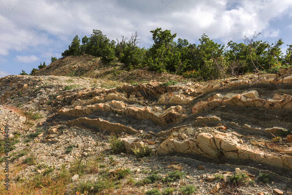 Shale mountains cement pits. The texture of the stone wall. Large stone cracks, the separation of the stone ridge. Background of stone wall texture. Stone for construction cement production Shale mountains cement pits. The texture of the stone wall. Large stone cracks, the separation of the stone ridge. Background of stone wall texture. Stone for construction cement production