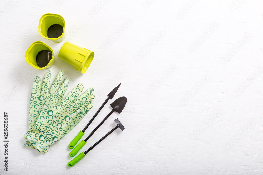 Rubber gloves and garden tools on white background