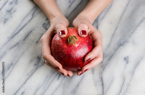 woman hands opening a pomagranate