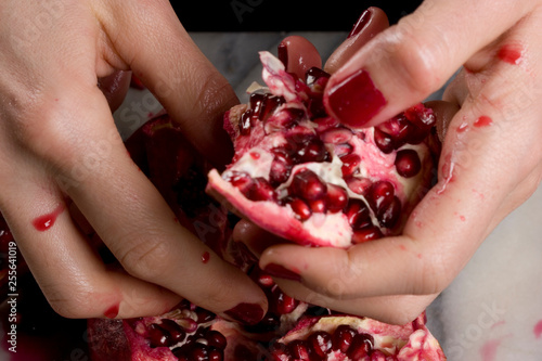 woman hands opening a pomagranate