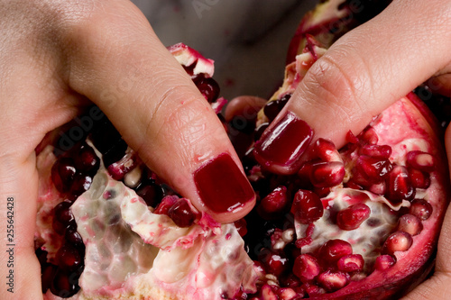 woman hands opening a pomagranate