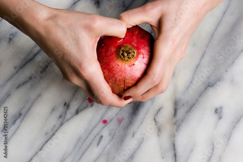 woman hands opening a pomagranate photo