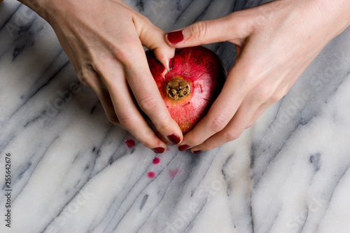 woman hands opening a pomagranate