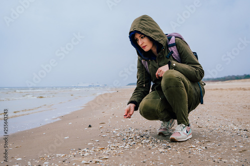 Kobieta zbiera muszle na plaży