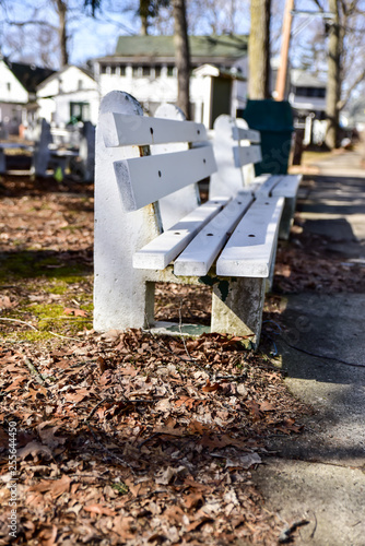 empty white bench along dirt road