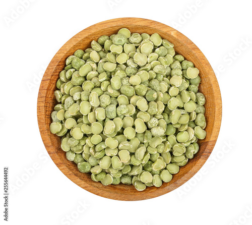 Green split peas in a wooden bowl isolated on white background. Top view