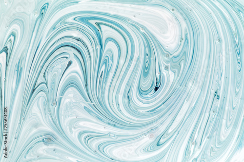 Abstract background for layouts. Stirring light turquoise and white paint close-up. Bright photo. photo