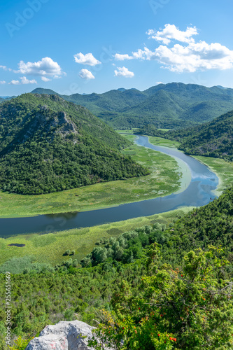 The picturesque meandering river flows among green mountains.