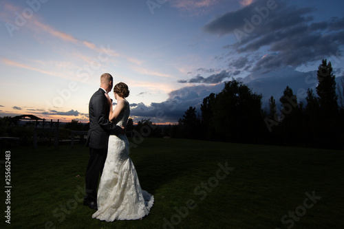 Dynamic bride and groom in front of colorful sunset
