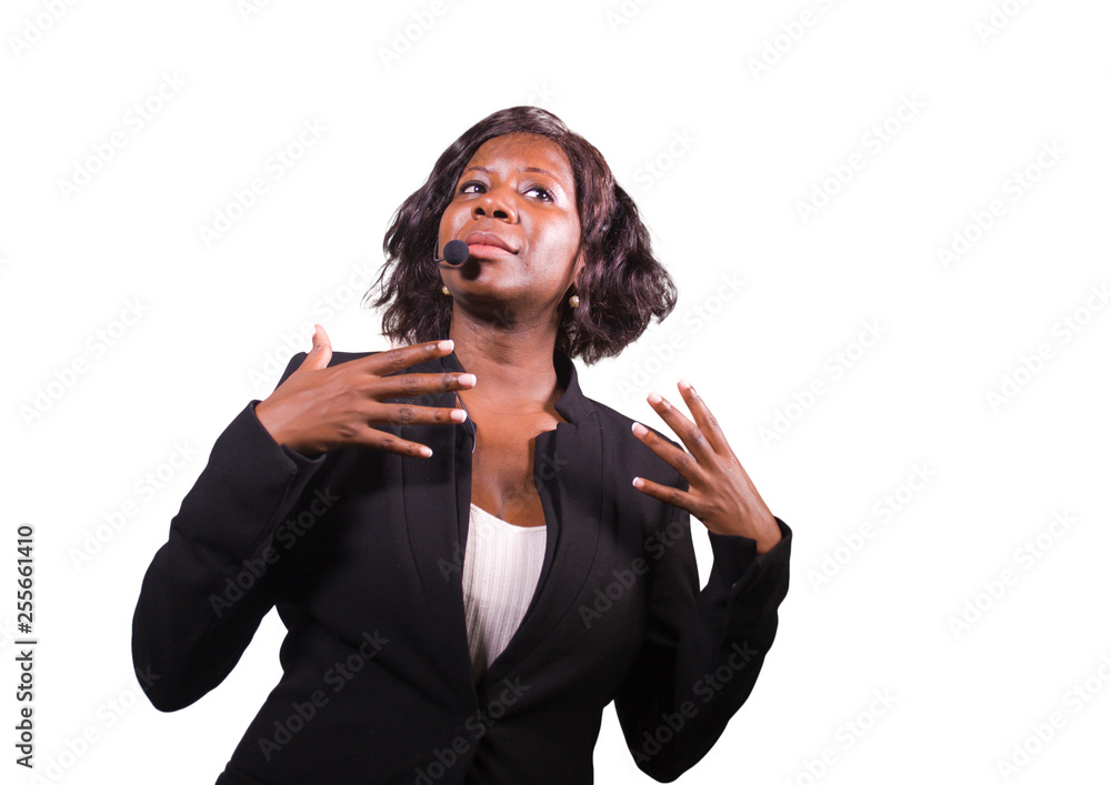 attractive confident business woman with microphone headset speaking to audience in auditorium at corporate event seminar in motivation and success coaching conference