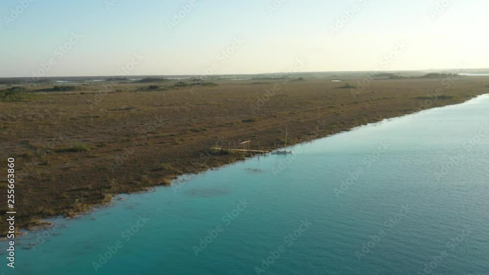 Aerial view of yacht at remote jetty on lake Bacalar the lagoon of seven colors in Quintana Roo, Mexico Aerial view of yacht at remote jetty on lake Bacalar the lagoon of seven colors in Quintana Roo, Mexico
