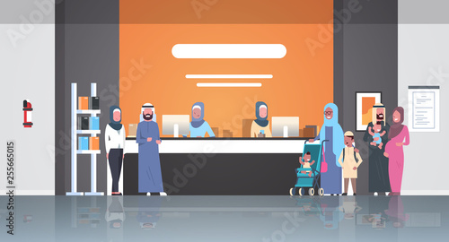 arabic patients in hijab standing line queue at hospital reception desk medical doctors consultation healthcare concept waiting hall clinic interior full length horizontal flat
