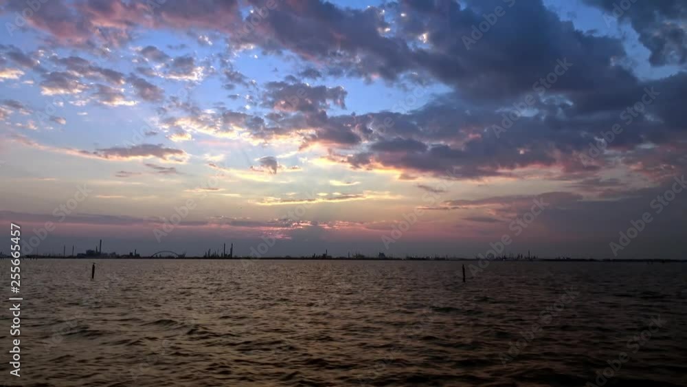 A Beautiful sunset view of the industry near Venice, Italy shot from a moving boat. A wide, stabilized shot. A Beautiful sunset view of the industry near Venice, Italy shot from a moving boat. A wide, stabilized shot.