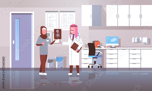 arab doctor and nurse examining x-ray hospital workers looking patient radiography cartoon characters full length medicine healthcare concept hospital clinic office interior photo