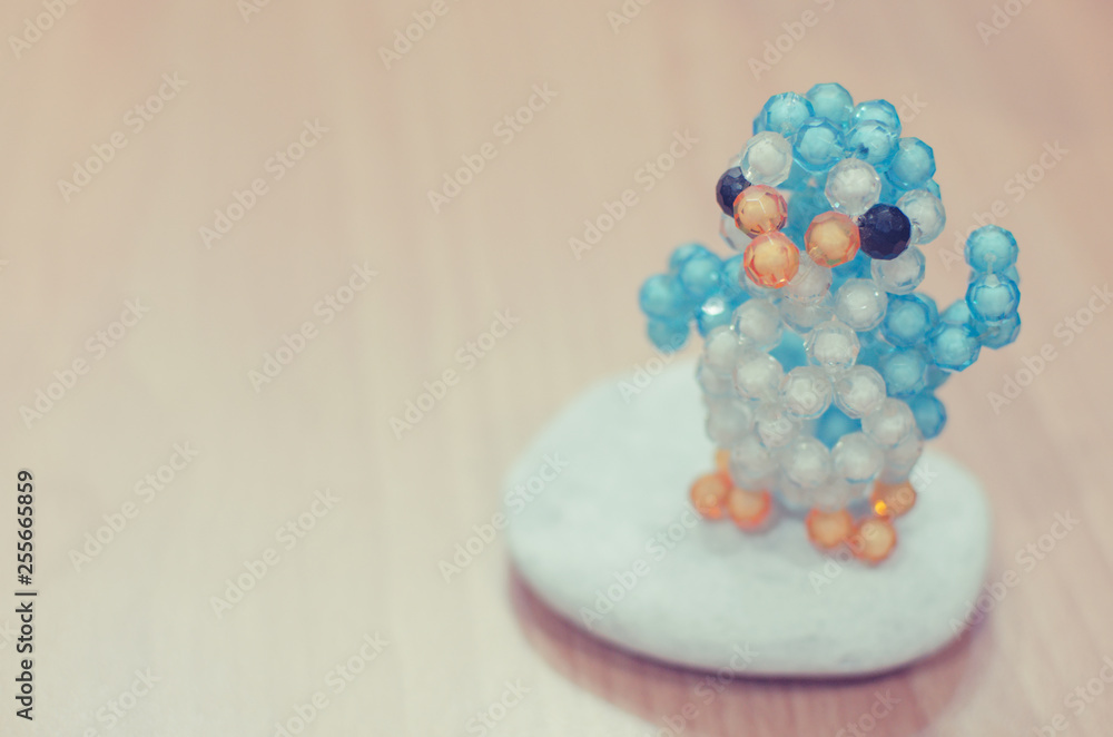 Penguin made of beads standing on a rock. Selective focus. Toned image. Penguin made of beads standing on a rock. Selective focus. Toned image.