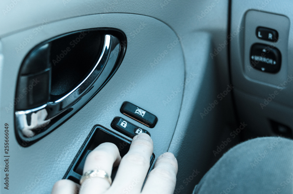 Obraz premium Closeup of hand touching button for locking car doors