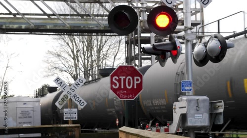 Active railroad crossing sign with train passing in the background.