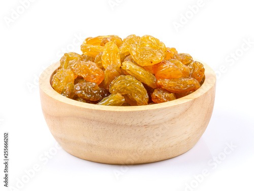 Yellow golden raisins in wood bowl isolated on white background. full depth of field