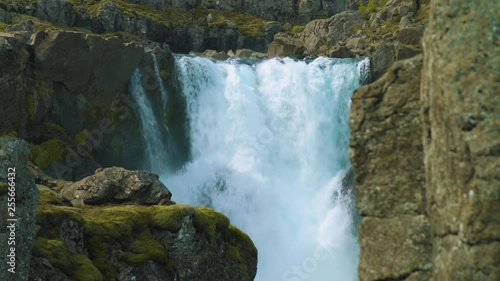 Sunny light on Fossardalur waterfall, Eastern Iceland. See through rocks. photo