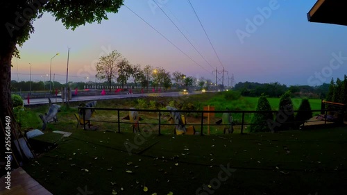 Day to night transition of highway traffic timelaps near to green paddy field photo