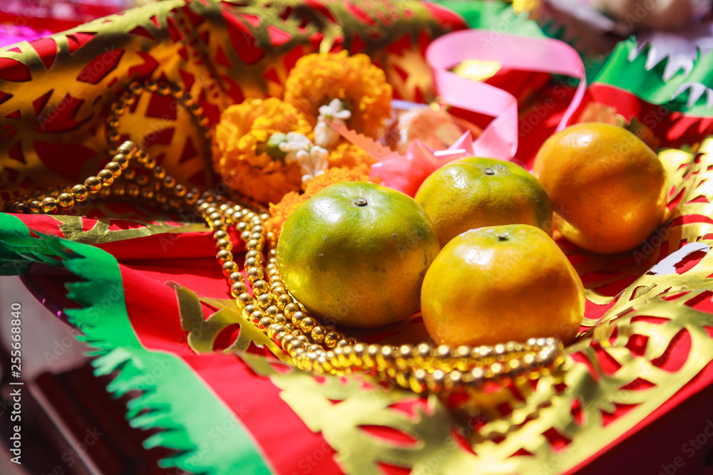 Orange Fruit, Rosary, Flower and Prayer Flag in Chinese Buddhist Temple, material offerings of traditional Mahayana Buddhist devotional practices for accumulation of merit. Religion and symbol concept